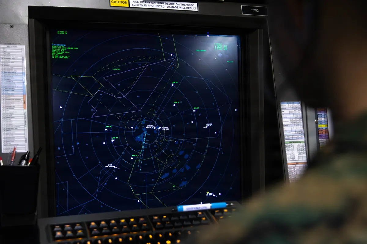 An operator’s screen showing air traffic tracks on a dark display.