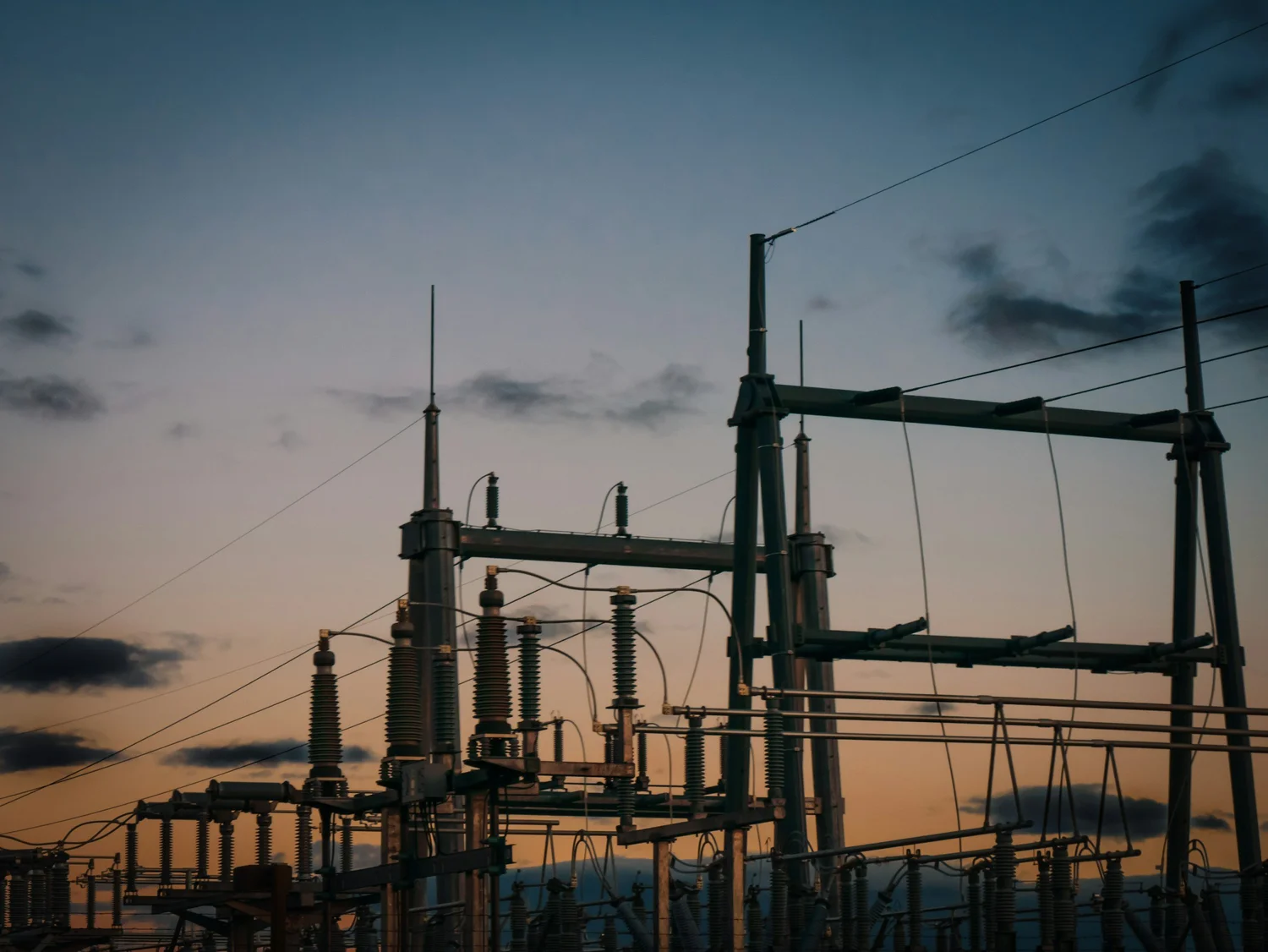 High-voltage electrical transmission substation at dusk.