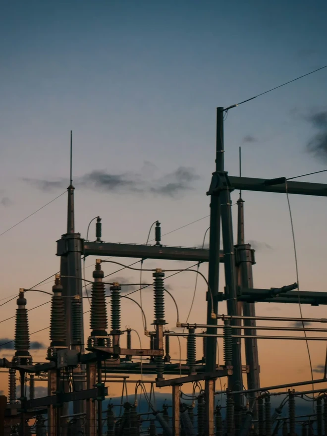 High-voltage electrical transmission substation at dusk.