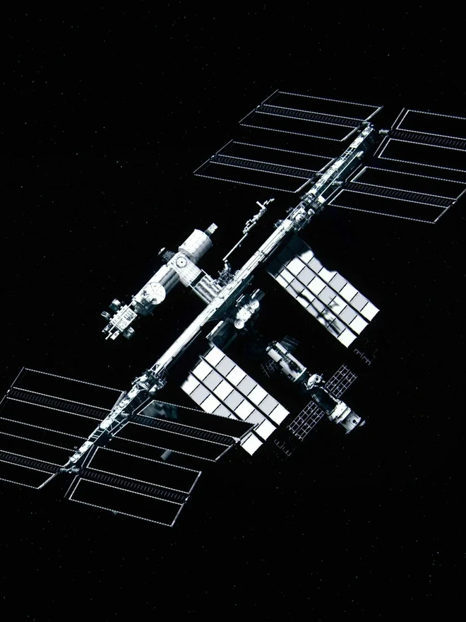 A satellite in orbit above Earth against a star field.